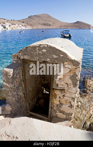 Old disused outside toilet, emptying straight into the harbour, Chalki Island near Rhodes, Dodecanese Islands, Greece. Stock Photo