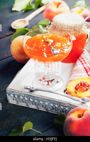 Peach jam with fresh peaches on rustic table. Homemade bio food concept Stock Photo