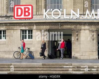 People exiting the Messe/Deutz railway station in Cologne, Germany with big DB logo Stock Photo