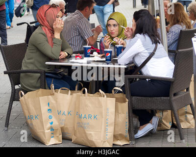 Female muslim friends, smoking and haveing a Pepsi, that have been shopping at Primark in Cologne, Germany Stock Photo