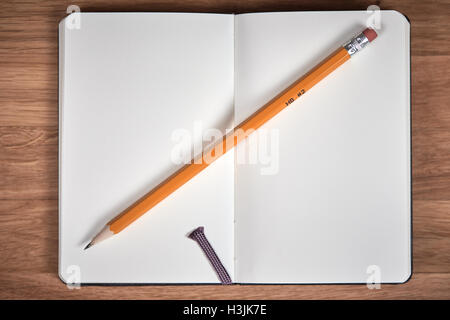 Open notebook and yellow pencil on a brown wooden table Stock Photo