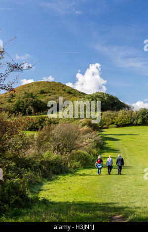 Walkers on the footpath to Golden Cap at the edge of Langdon Woods above Seatown, Dorset, England, UK Stock Photo