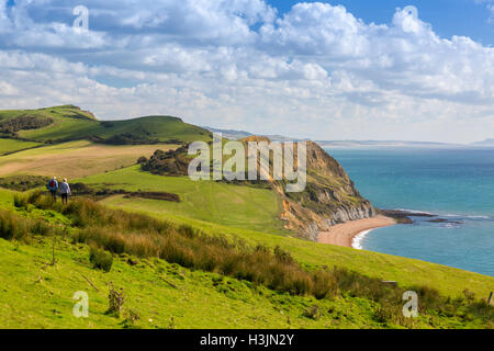 Walkers descending from the summit of Golden Cap on the SW Coast Path, Jurassic Coast, Dorset, England, UK Stock Photo