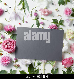 Beautiful pink and white flowers with empty dark notebook on a white background, copy space for your text Stock Photo