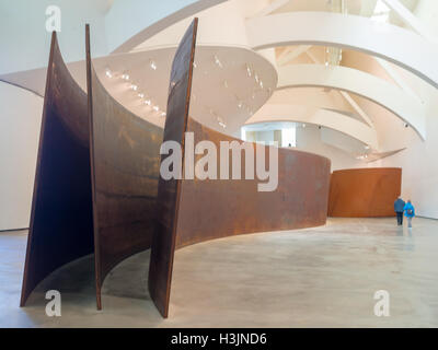 Visitors walking around Richard Serra steel sculptures in Guggenheim Bilbao Museum Stock Photo