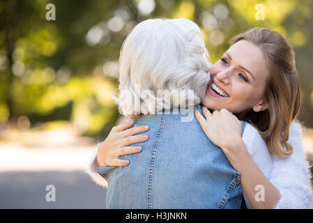 Two amused women embracing in the park. Stock Photo