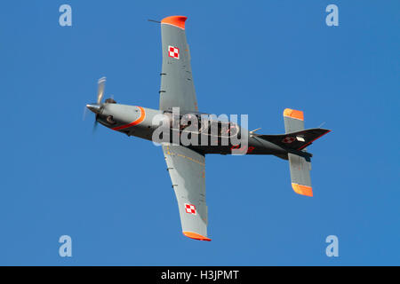 Military aircraft. Polish Air Force PZL-130 Orlik single engine propeller powered trainer plane flying in a blue sky at an air display Stock Photo