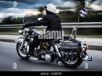 Man Riding a Harley Davidson Motorcycle at Speed, with Cuban Pennant, Cuba Stock Photo