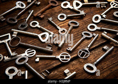 many different keys on brown wooden background. Stock Photo