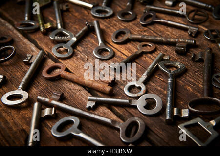 many different keys on brown wooden background. Stock Photo