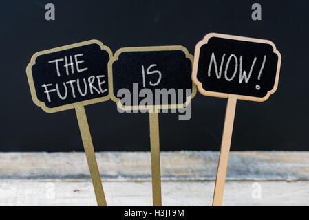 Business message THE FUTURE IS NOW written with chalk on wooden mini blackboard labels Stock Photo