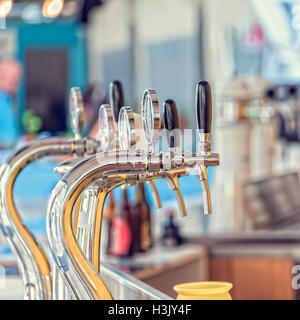 Draught beer taps and other beverages in a bar. Stock Photo