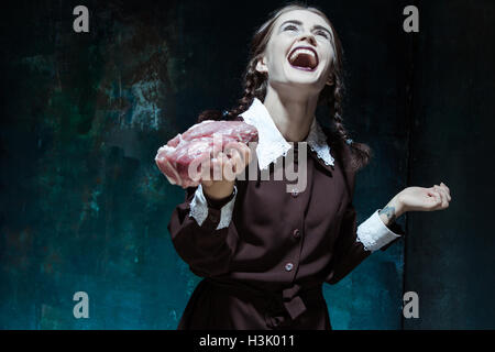 Bloody Halloween theme: crazy girl with raw meat Stock Photo