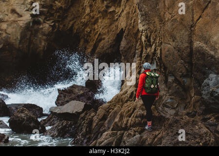 Hiker climbing over rocks, Big Sur, California, USA Stock Photo