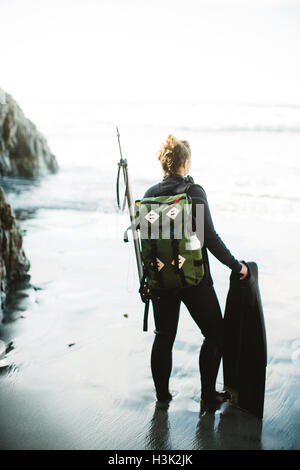 Diver with speargun on beach, Big Sur, California, USA Stock Photo
