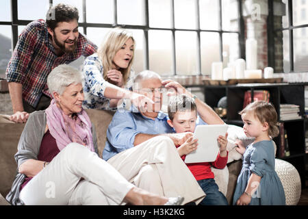 Three generation family using digital tablet at home Stock Photo