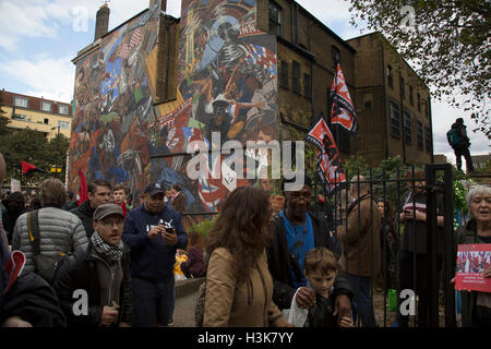 London,  UK. 9th October, 2016. Anti fascists gather in front of the Battle of Cable Street mural in St Georges Gardens during the Cable Street 80 march and rally through Whitechapel to mark the 80th anniversary of the Battle of Cable Street on 9th October 2016 in London, United Kingdom. The demonstration marks the day when tens of thousands of people across the East End, joined by others who came to support them, prevented Oswald Mosley’s British Union of Fascists invading the Jewish areas of the East End. Credit:  Michael Kemp/Alamy Live News Stock Photo