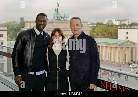 Berlin, Germany. 10th Oct, 2016. French actor Omar Sy (L-R), British actor Felicity Jones and American actor Tom Hanks in front of the Brandenburg Gate during the 'Inferno' photocall in Berlin, Germany, 10 October 2016. Photo: Britta Pedersen/dpa/Alamy Live News Stock Photo