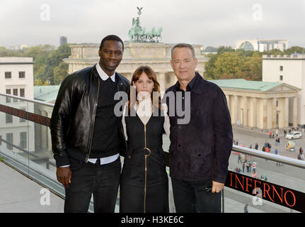 Berlin, Germany. 10th Oct, 2016. French actor Omar Sy (L-R), British actor Felicity Jones and American actor Tom Hanks in front of the Brandenburg Gate during the 'Inferno' photocall in Berlin, Germany, 10 October 2016. Photo: Britta Pedersen/dpa/Alamy Live News Stock Photo