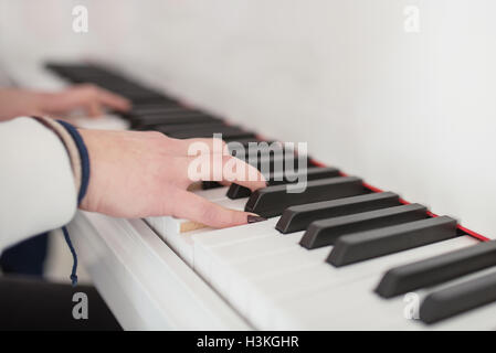 Women's hands on the keyboard of the piano Stock Photo