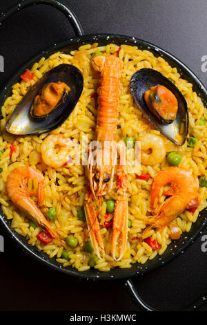 Spanish seafood paella on black background Stock Photo