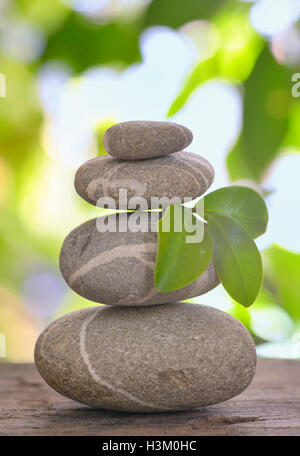 Balanced pebbles isolated on wooden table Stock Photo