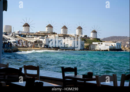View of windmills from seaside cafe in Mykonos Stock Photo