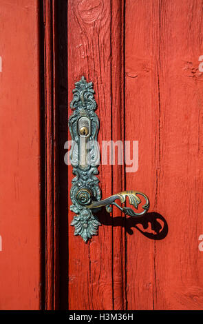 Vintage Ornate front door handle image on a red colour front door house art in Hvammstanga, Iceland, pt Europe objects Stock Photo