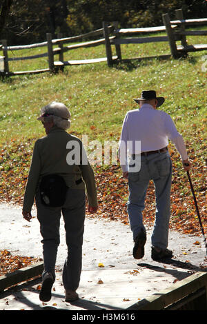 Elderly couple walking on a trail in a sunny day Stock Photo