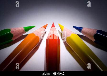 Five pencils (dark blue, green, red, yellow, orange) on a dark background.  Available in high-resolution and several sizes. Stock Photo