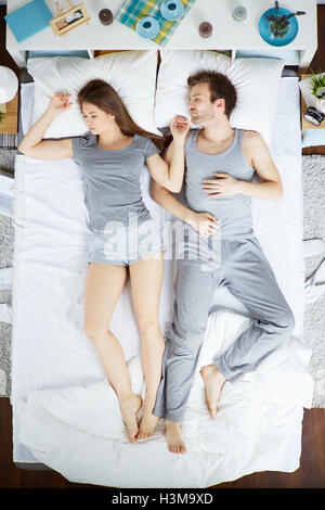 Young couple sleeping together on bed Stock Photo