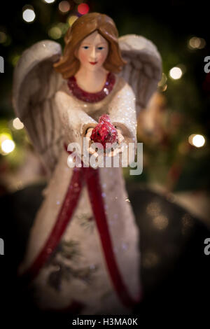 A beautiful Christmas angel offers the gift of a red cardinal. Stock Photo