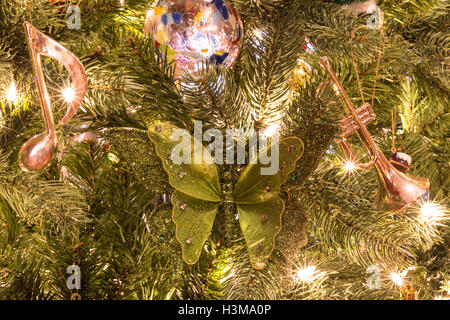 Musical Christmas ornaments on a Christmas tree lit with white lights. Stock Photo