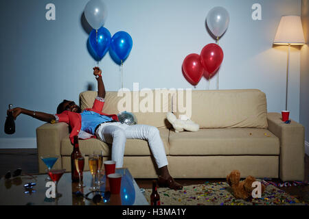 Relaxed guy with bottle lying on sofa Stock Photo