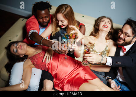 Flutes with champagne in hands of ecstatic friends during toast Stock Photo