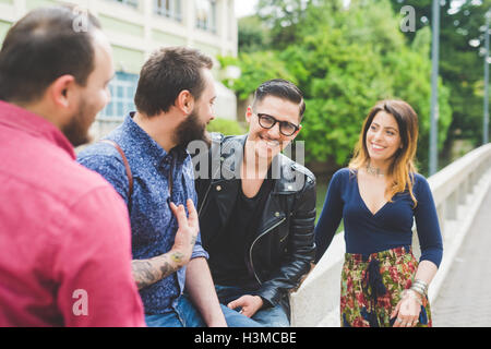 Group of friends chatting by roadside Stock Photo