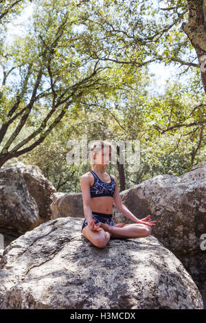 Woman practising yoga in forest Stock Photo