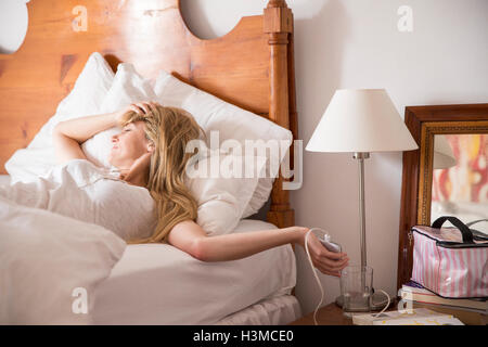 Woman waking up in bed Stock Photo