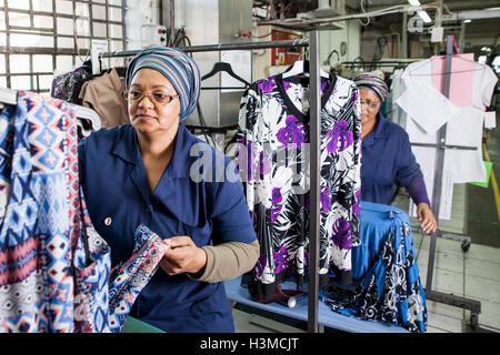 Workers examining dress in garment factory Stock Photo