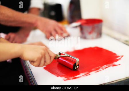 Close-up of hands using ink roller for letterpress printing in book arts workshop Stock Photo