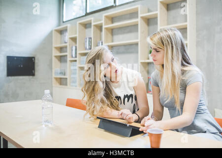 Co-workers working on digital tablet in office Stock Photo