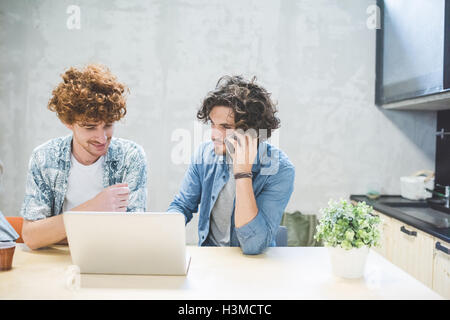 Co-workers working on laptop in office Stock Photo