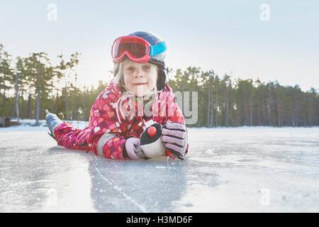 Portrait of girl lying on her front on frozen lake, Gavle, Sweden Stock Photo
