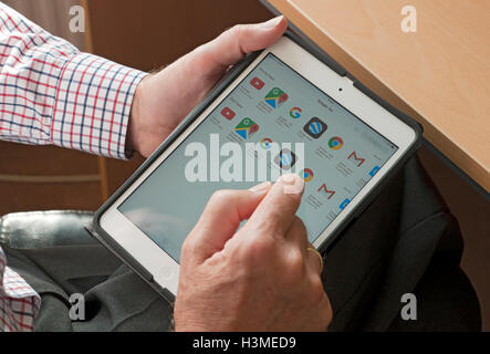 Close up of person man looking at Google apps app on tablet ipad England UK United Kingdom GB Great Britain Stock Photo