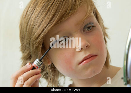 young boy putting makeup on pretending to be a girl Stock Photo