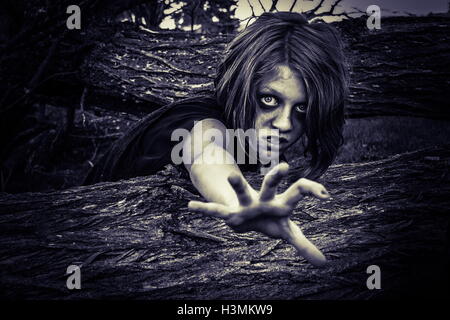 haunted imaged of child crawling in dark cemetary among old trees