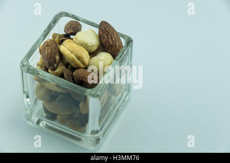 a bunch of assorted nuts in a small glass bowl Stock Photo