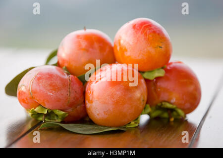 ripe persimmons on a table, outdoor Stock Photo