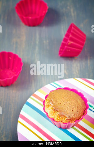 Homemade muffin on a plate with empty cups, shallow depth of field. Stock Photo