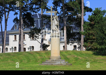 Baroque statue of Saint Helen holding a cross in the gardens of the Festetics Palace (1745) in Keszthely, Hungary Stock Photo